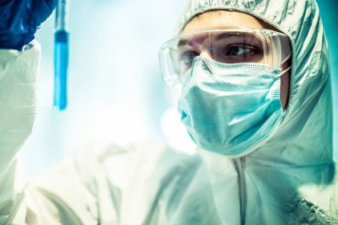 Corona virüsü konsepti. Erkek doktor test tüpünü inceliyor.
