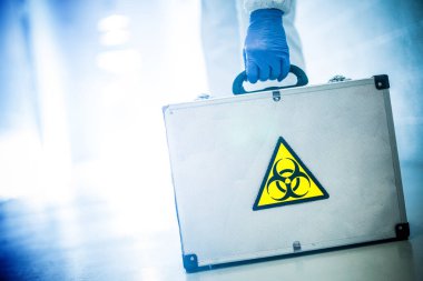 Corona virüsü konsepti. Erkek doktor biyolojik tehlike vakası alıyor.