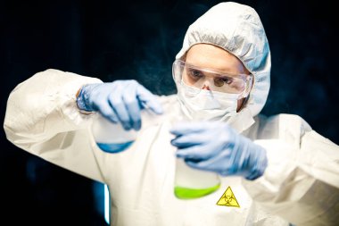 Corona virüsü konsepti. Erkek doktor cam şişeyi inceliyor.