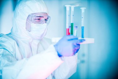 Corona virüsü konsepti. Erkek doktor test tüplerini inceliyor.