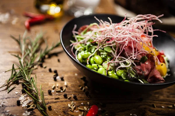 Poke with beef served in a black bowl in restaurant — Stock Photo, Image