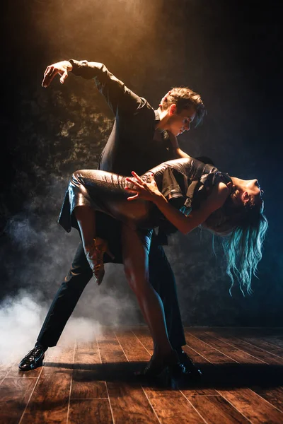 Jeune couple dans des robes de soirée élégantes danse — Photo