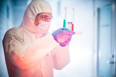 Corona virüsü konsepti. Erkek doktor test tüplerini inceliyor.