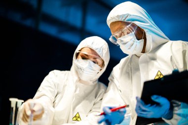 Corona virüsü konsepti. İki doktor test tüpünü inceliyor.