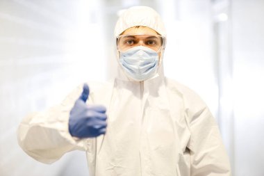 Corona virüsü konsepti. Erkek doktor baş parmağını gösteriyor.