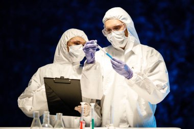 Corona virüsü konsepti. İki doktor test tüpünü inceliyor.