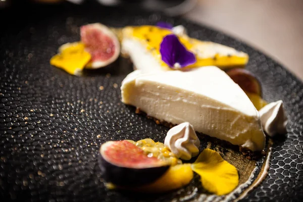 Cheesecake met passievrucht geserveerd op een bord in restaurant — Stockfoto