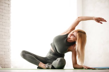 Evde yoga meditasyonu. Güzel genç bayan vücut çalışıyor.