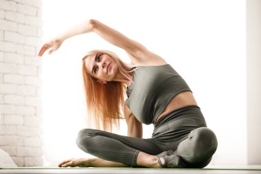 Evde yoga meditasyonu. Güzel genç bayan vücut çalışıyor.