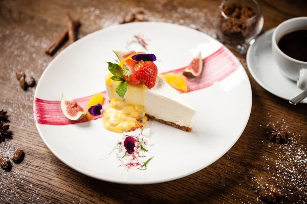 Cheesecake met passievrucht vijg en sinaasappelmoes op een wit bord. Heerlijke gezonde gastronomische dessert food closup geserveerd voor het diner in restaurant. — Stockfoto
