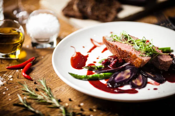 Pechuga de pato con espárragos, ensalada y salsa en plato blanco. Delicioso y saludable asado a la parrilla filete de ave comida de cierre servido en una mesa para el almuerzo en la cocina moderna restaurante gourmet . — Foto de Stock