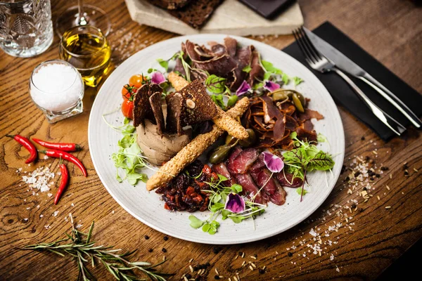 Bandeja de carne para dos: Brisket de carne seca, filete de pato seco, paté de hígado de res, striploin de cordero seco, mermelada de arándanos y grissini. Deliciosos bocadillos antipasti tradicionales italianos sanos —  Fotos de Stock