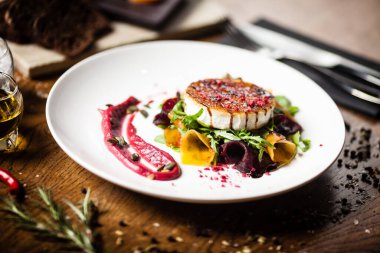 Izgara keçi peynirli salata turşulu pancar ve kabak, kızılcık reçeli, beyaz tabakta kabak çekirdeği. Lezzetli sağlıklı Akdeniz geleneksel vejetaryen yemekleri öğle yemeği için bir masada servis edilir.