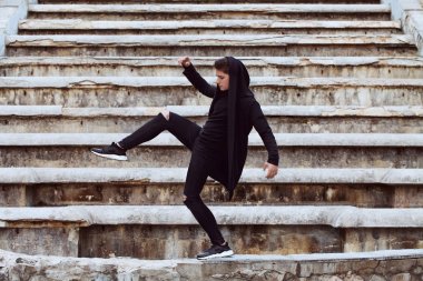 Adam siyah kılığına girmiş bir çağlayan fonunda poz 