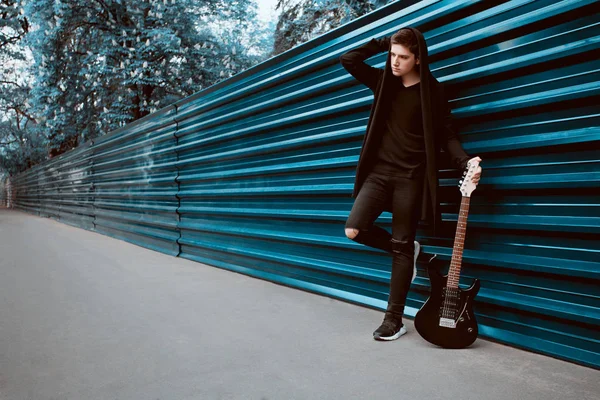 Elektro gitar macenta çit arka plan üzerinde olan adam portresi. Söz yazarı kavramı