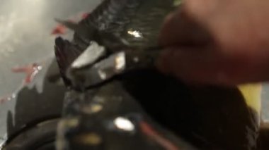 Balıkları soyan kadına yaklaş.