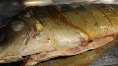 Kadınlar çiğ balıklara sos katar ve defne yaprağıyla doldurur.