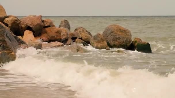 美しいビーチと海 カラフルな海の波 海の水 午後の太陽の下でのビーチでの岩 空気中の潮風 黄金の砂のビーチ 長い平らな波 ビーチのサイドビュー — ストック動画