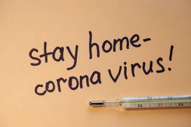 Düz yatıyordu. Beyaz kağıtta siyah kalemli cümleler Evde Kalın. Doktor bir uyarı yaptı. Evde kal. Coronovirus COVID-19 konsepti 