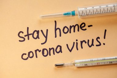 Düz yatıyordu. Beyaz kağıtta siyah kalemli cümleler Evde Kalın. Doktor bir uyarı yaptı. Evde kal. Coronovirus COVID-19 konsepti 