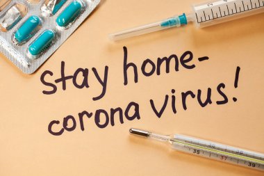 Düz yatıyordu. Beyaz kağıtta siyah kalemli cümleler Evde Kalın. Doktor bir uyarı yaptı. Evde kal. Coronovirus COVID-19 konsepti 
