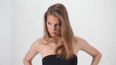 Beyaz arka planda poz veren güzel bir model. Kameranın önünde poz veren kız. Genç kadın portresi. Mükemmel ciltli bir kadın.