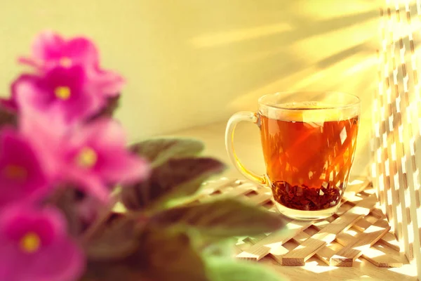 Cup glass of black tea on a wooden background. Morning, sunny an — Stock Photo, Image