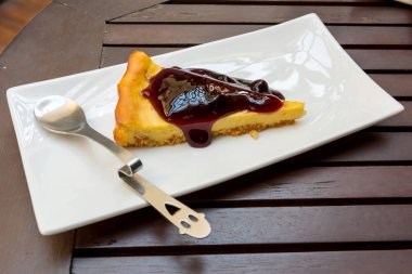 Yaban mersinli Cheesecake bir plaka üzerinde küçük kaşık ile