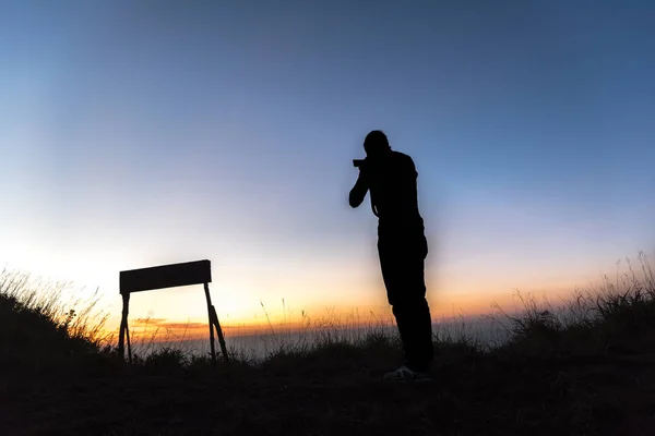 Silhouet van een fotograaf schieten zonsondergang scène — Stockfoto