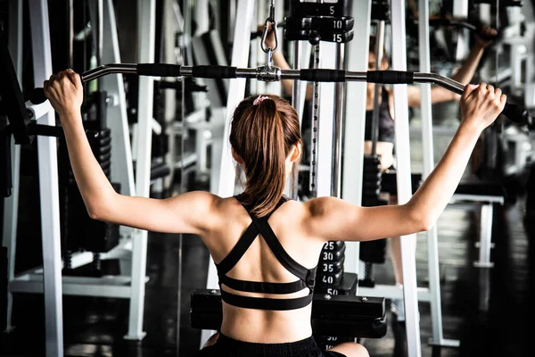 Mulher exercitar os músculos da construção no ginásio — Fotografia de Stock