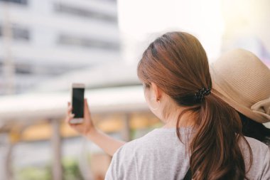 Asyalı turistler akıllı telefonlarıyla kendi fotoğraflarını çekiyorlar.