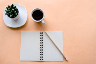 Not defteri ve kahve fincanı olan üst kattaki ofis masası.