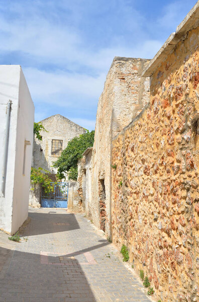 The narrow street with old houses in the historic part of Hersonissos, Crete, Greece.