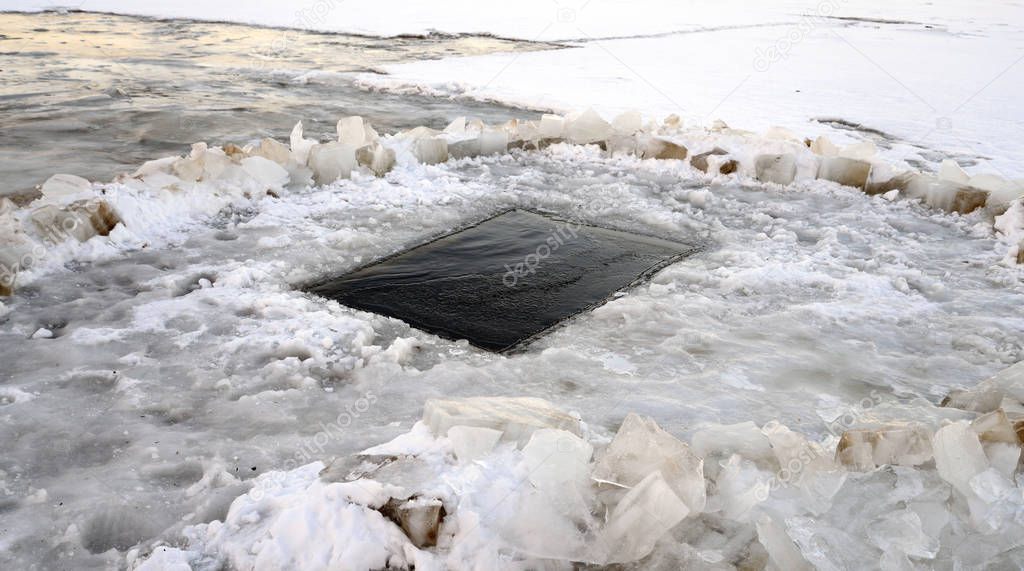 Frozen river with ice-hole