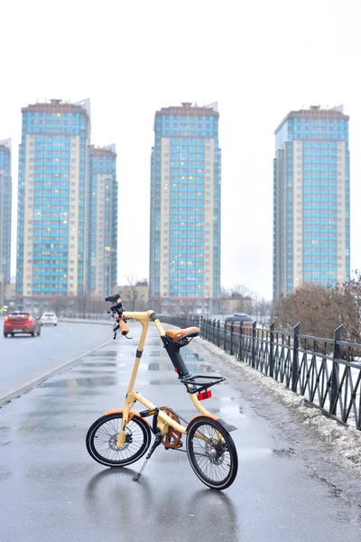 A háttérben a felhőkarcolók kerékpár Strida. — Stock Fotó