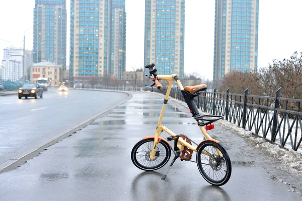 Bicycle Strida on the background of skyscrapers. — Stock Photo, Image
