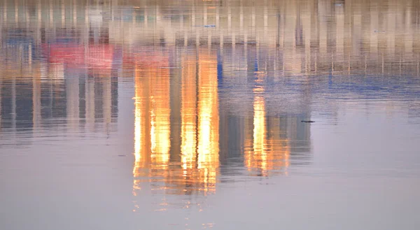 Gratte-ciel au coucher du soleil reflété dans l'eau . — Photo