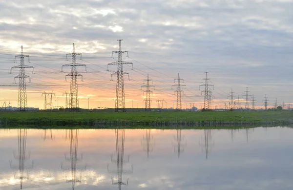 De lijn van de macht op het platteland bij zonsondergang. — Stockfoto