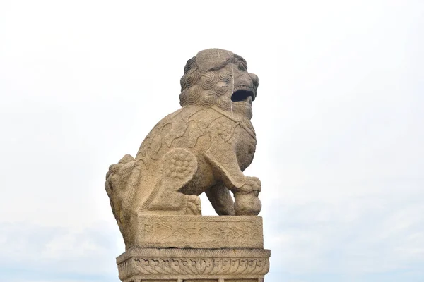 Leão de granito no fundo céu nuvem . — Fotografia de Stock