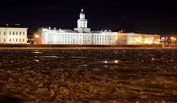 Weergave van Universiteit Embankment en bevroren rivier de Neva's nachts. — Stockfoto