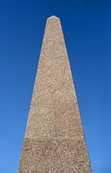 Granite stele on blue sky background. — Stock Photo, Image