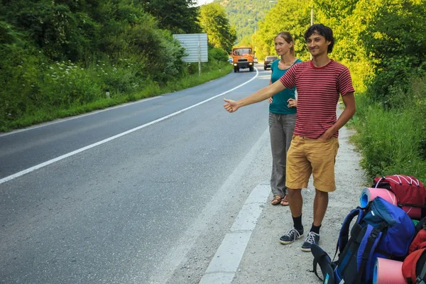 Szczęśliwy autostopowiczów na drodze — Zdjęcie stockowe