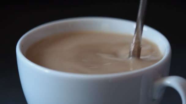 Main en remuant tasse de café  