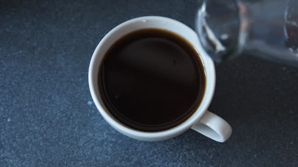 Pouring milk into coffee cup — Stock Video