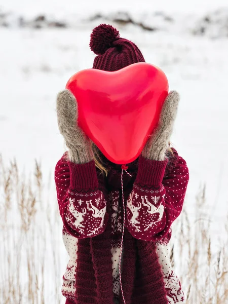 Woman holding heart balloon