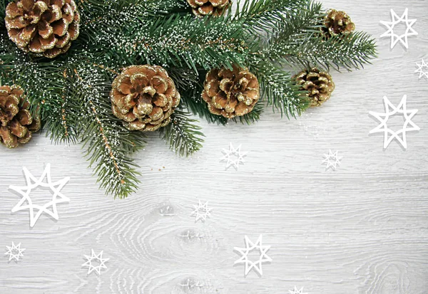 Новогодняя и рождественская композиция. Сосновые шишки, еловые ветви на деревянном белом фоне — стоковое фото