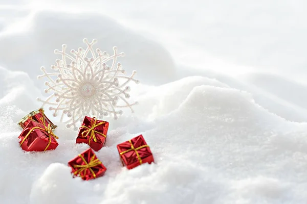 Coffrets cadeaux rouges et flocons de neige sur la neige — Photo