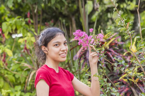 Jeune femme avec fleur dans le jardin — Photo