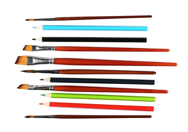 Štětce malířské a barevné tužky izolované na bílém — Stock fotografie