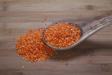 Tahta kaşık rattan bambu masada kırmızı mercimek yığını